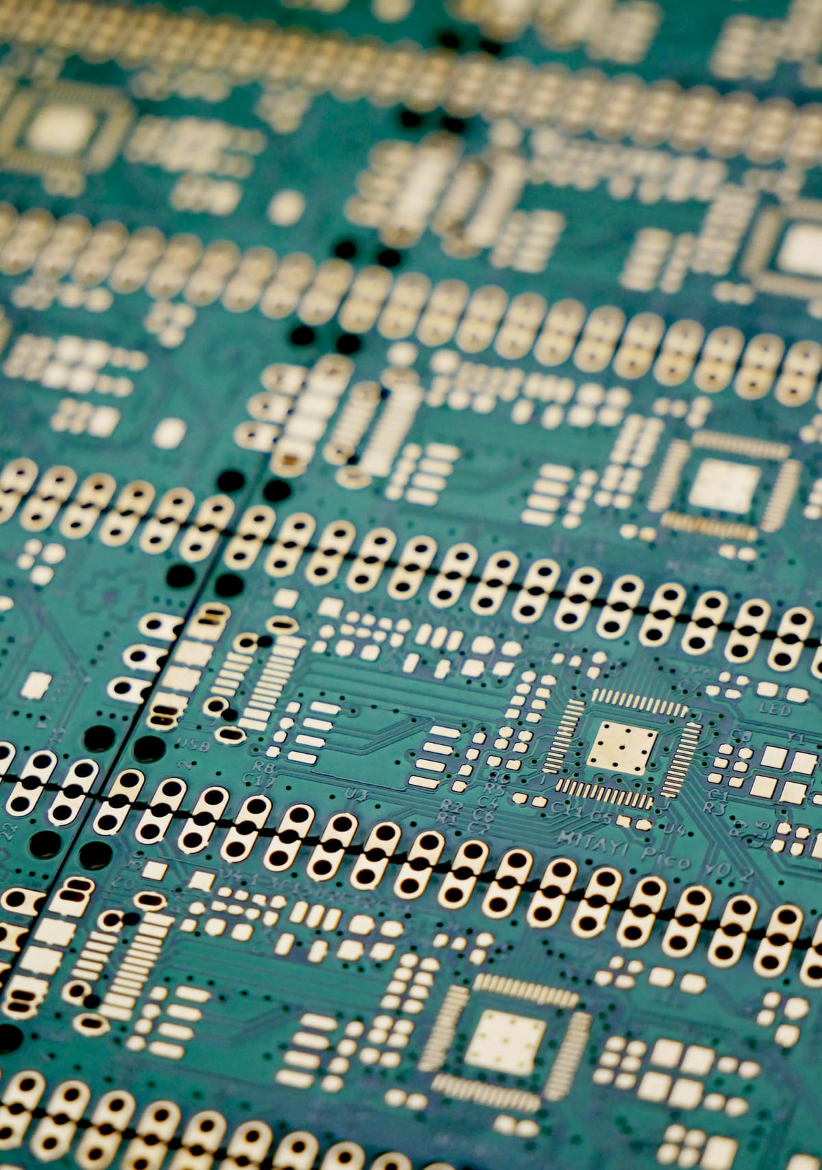 A green printed circuit board, photographed close up.
