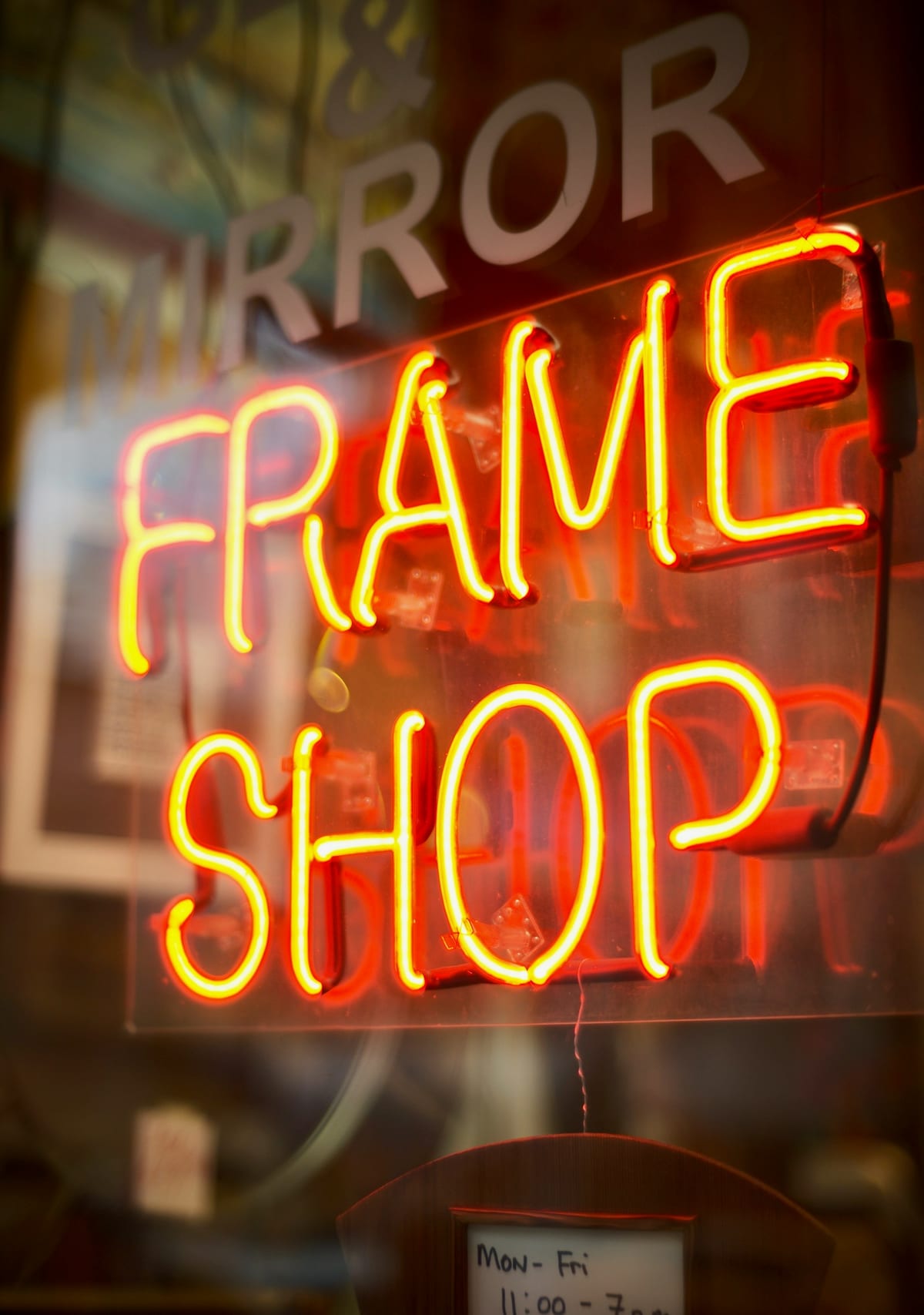 A neon shop sign glowing in a window.