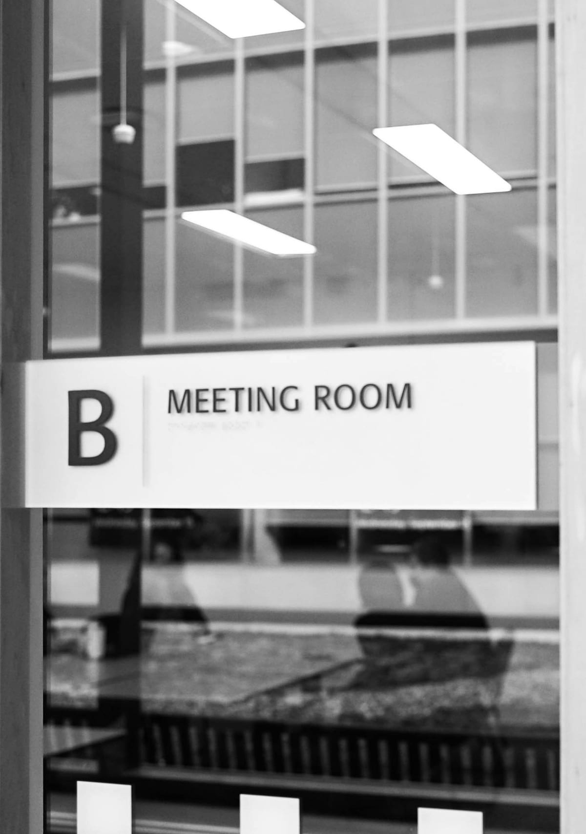 A meeting room door with a frosted glass sign.